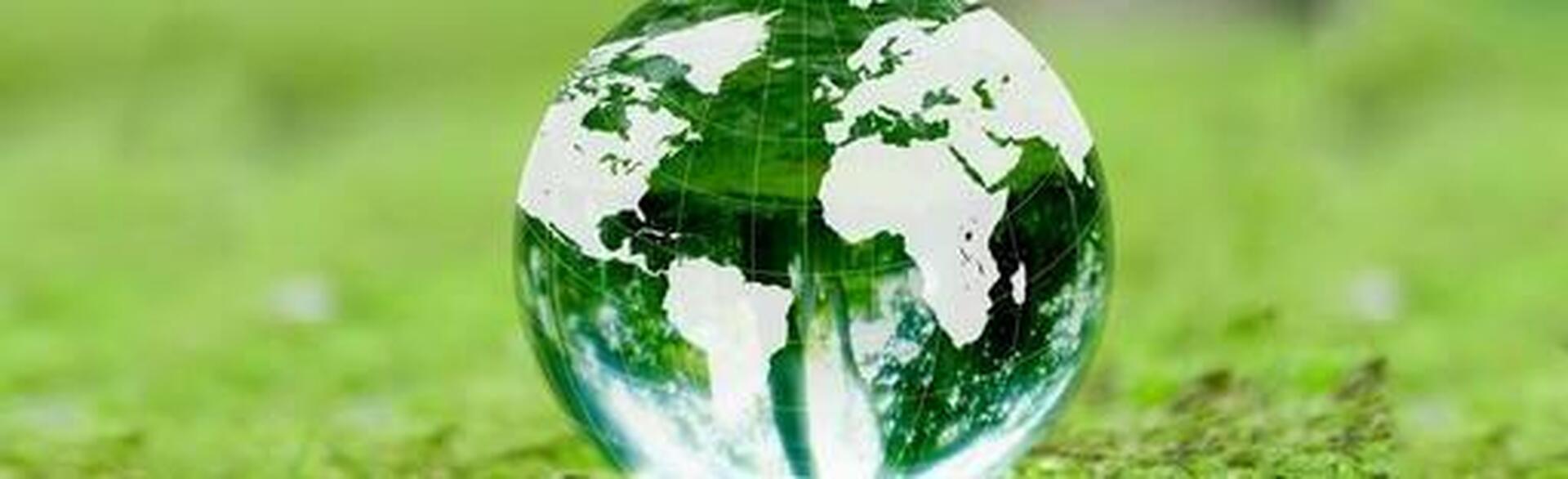 鮮やかな緑の苔の上に置かれたガラス製の地球儀と環境に優しい地球イメージ
